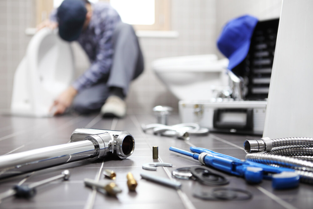 Plumber Inspecting Under-sink Pipes